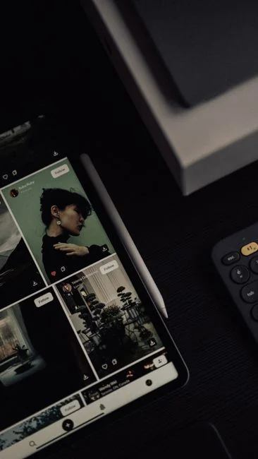 Close-up of hands using a tablet, displaying a digital interface.